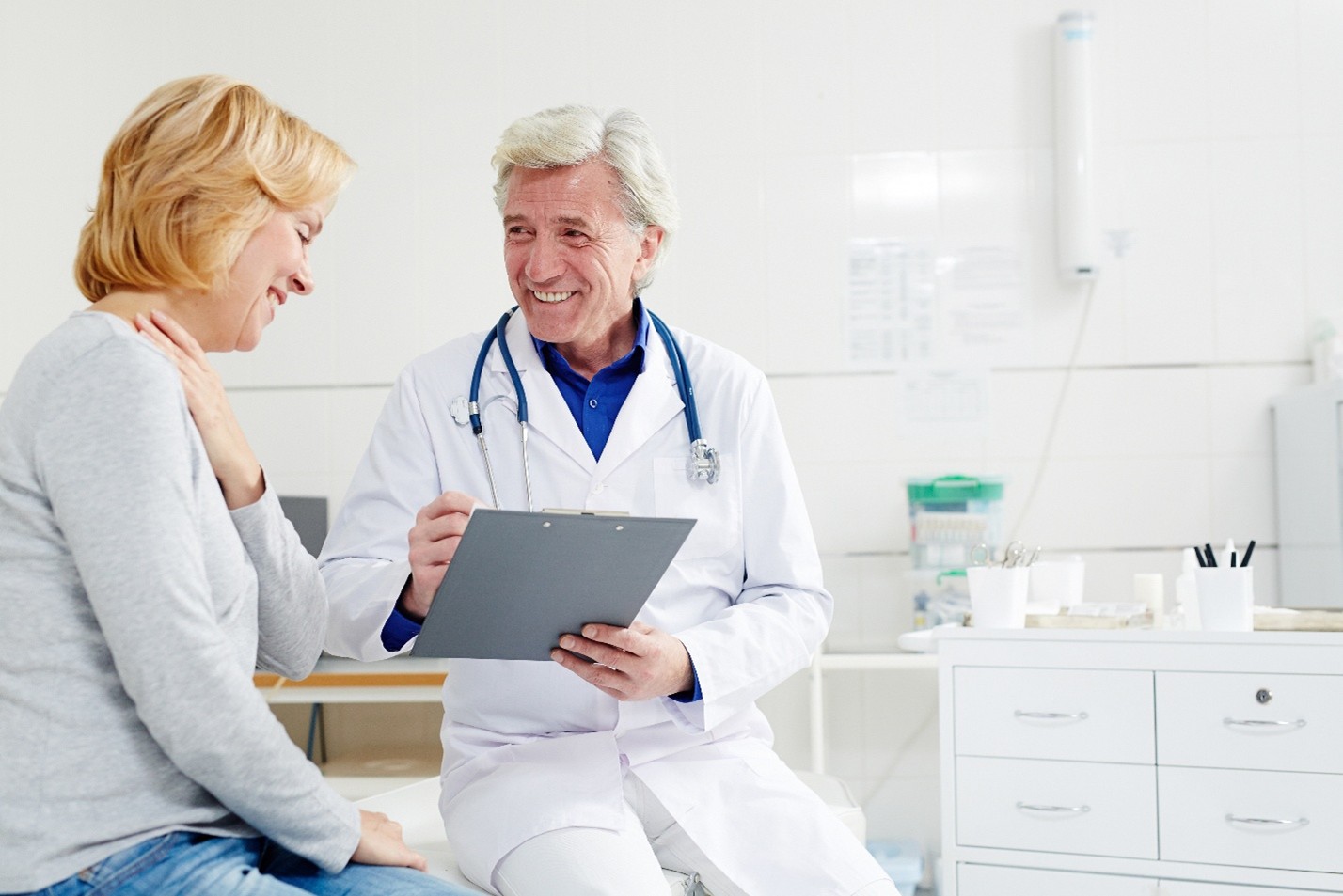 Doctor sits with patient that has chest pain.